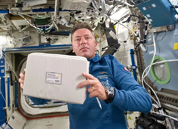 Astronaut holding the Airgloss sensor aboard the ISS